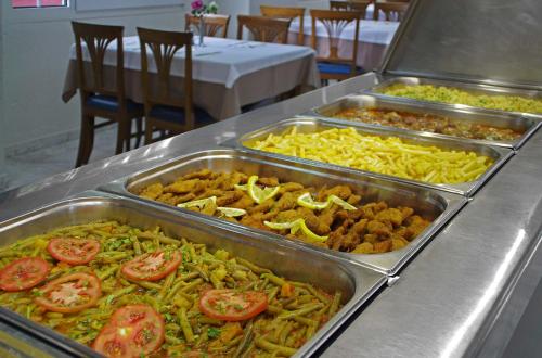 a buffet line with trays of different types of food at Sun Beach Hotel in Platamonas