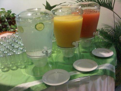 three glasses of drinks sitting on a table with spoons at Hotel Residencial in Mérida