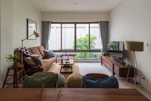 a living room with a couch and a large window at APT476 in Bangkok