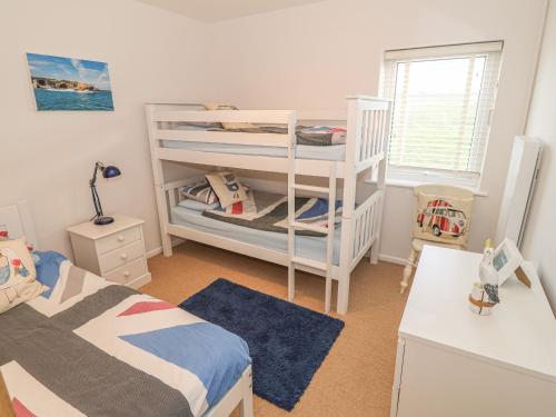 a bedroom with two beds and a bunk bed at Happy Daze in Pwllheli