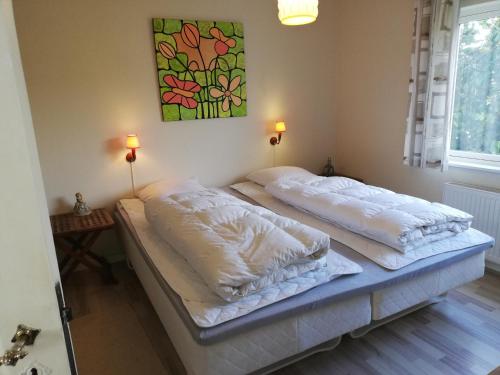 two twin beds in a room with two lamps at Holiday Home Kirkeby Feriehus in Roslev