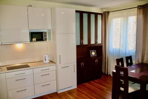 eine Küche mit weißen Schränken, einem Tisch und einem Esszimmer in der Unterkunft Apartament Kasztanowy Centrum in Zakopane