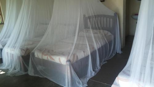 a bed covered in mosquito nets in a room at Heritage Safari Lodge in Pakwach East