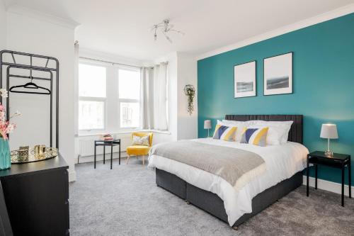 a bedroom with a bed and a blue wall at Luxury Apartment 2bed & Parking - East London - by Damask Homes in Ilford