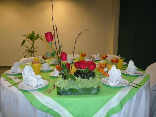 a table with plates of food and flowers on it at Hotel Residencial in Mérida