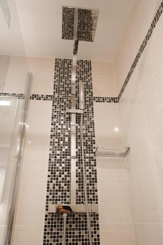 a bathroom with a black and white tile shower at Little Hôtel in Paris