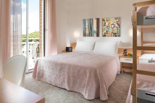 a bedroom with a bed and a balcony at Hotel Bassetti in Cervia