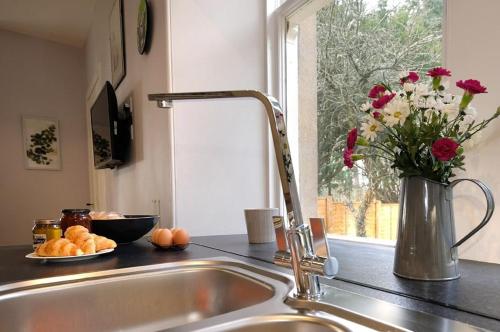 a kitchen sink with a vase of flowers next to a window at East Lodge in Dyke