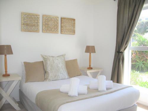 A bed or beds in a room at Beachfront Cottage - Hermanus Whale View