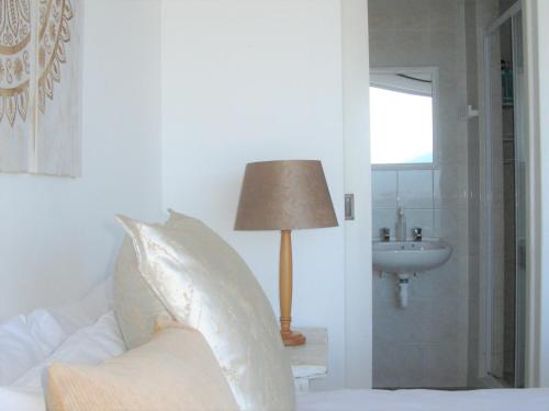 A bed or beds in a room at Beachfront Cottage - Hermanus Whale View