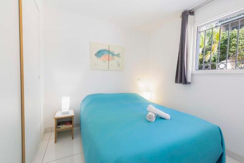une chambre avec un lit bleu et une fenêtre dans l'établissement Villa Francia, à Cannes