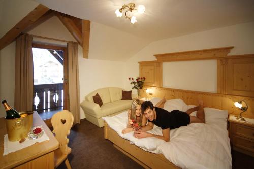 a woman and a girl laying on a bed at Romantik Villa Cesanueva in Selva di Val Gardena