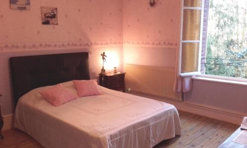 Un dormitorio con una cama con paredes rosas y una ventana en Bernafay Wood B&B, en Montauban-de-Picardie