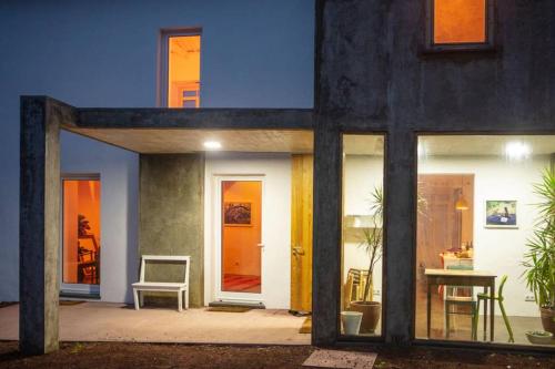 a house with glass doors and a table and a chair at Casa das Artes in Serreta