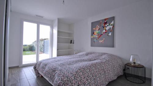 une chambre blanche avec un lit et une fenêtre dans l'établissement Villa Saquèdes, à Sainte-Maxime