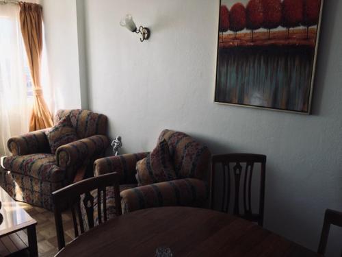 sala de estar con 2 sillas y mesa en Departamento Amoblado Carlos Pezoa Veliz, en Antofagasta