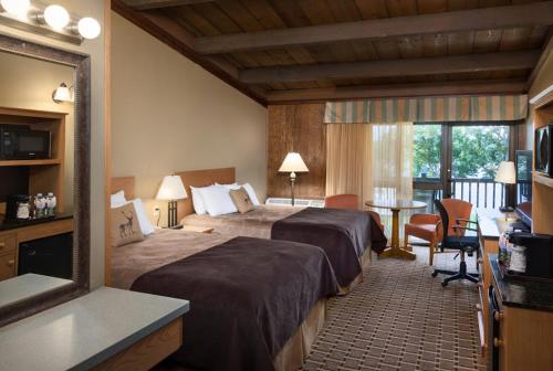 a hotel room with two beds and a table at Hueston Woods Lodge and Conference Center in Oxford