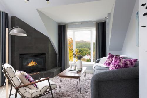a living room with a fireplace and a couch at Field Guide Lodge in Stowe