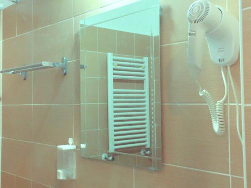a shower with a mirror and a hairdryer at San Daniele Bundi House in Rome