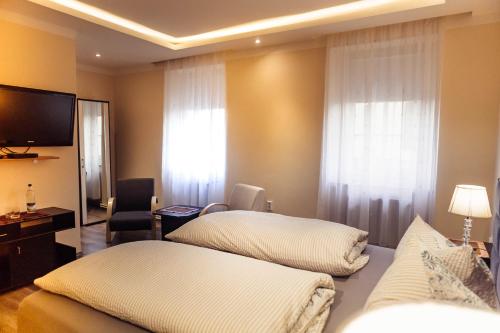 ein Hotelzimmer mit 2 Betten und einem Flachbild-TV in der Unterkunft Hotel und Restaurant Peking in Riesa