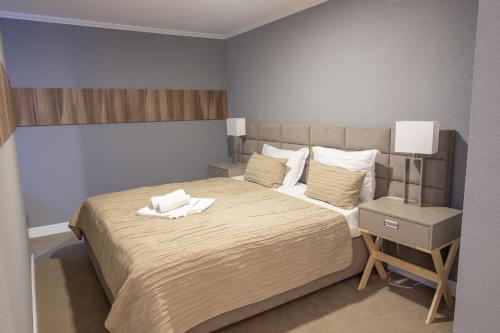 Un dormitorio con una cama y una mesita de noche con una toalla blanca. en Hotel Roberto Slanic Prahova en Slănic
