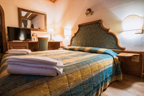 ein Hotelzimmer mit einem Bett und einem Spiegel in der Unterkunft Hotel Sporting in Val di Zoldo