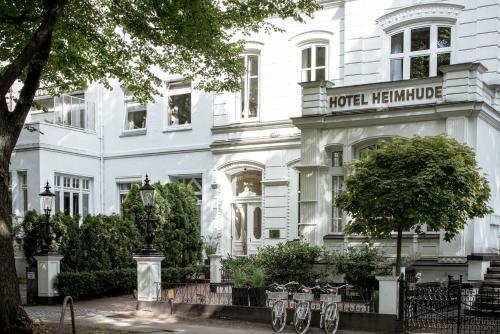 un edificio blanco con un letrero que lee Hotel Heinemann en stilwerk Hotel Heimhude, en Hamburgo