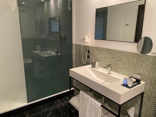 a bathroom with a sink and a shower at Postumia Hotel Design in Oderzo