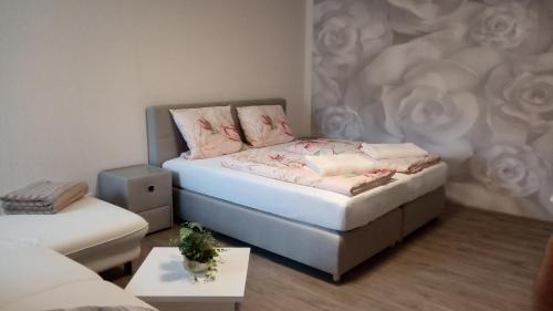 a small bedroom with a bed with flowers on it at Gästehaus - Café Frank in Antweiler