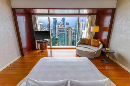 a room with a bed and a couch and a large window at Grand Hyatt Kuala Lumpur in Kuala Lumpur