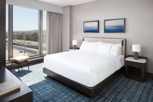 a bedroom with a white bed and a large window at Grand Hyatt at SFO in Millbrae
