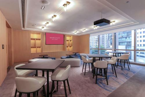 a restaurant with tables and chairs and a large window at Grand Hyatt Kuala Lumpur in Kuala Lumpur