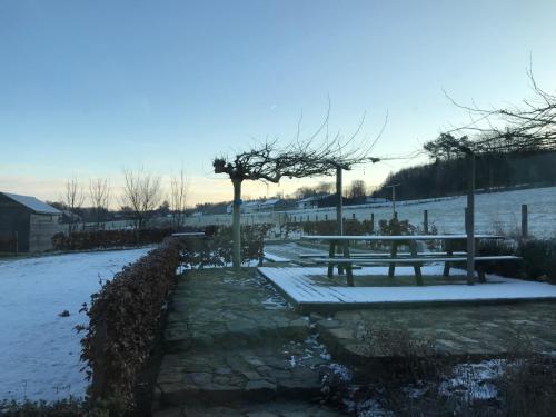 a picnic table with snow on it in a park at Vakantiewoning mogimont in Mogimont