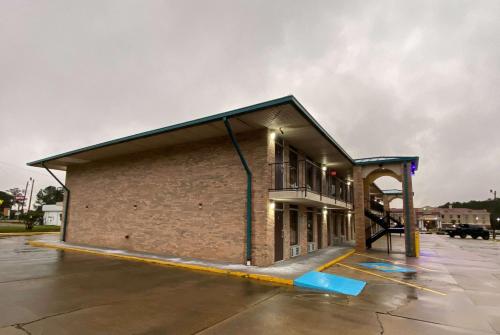 a brick building with a balcony in a parking lot at Days Inn by Wyndham Forest in Forest