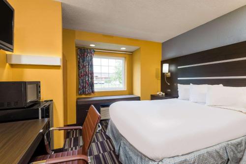 a hotel room with a large bed and a window at Microtel Inn & Suites by Wyndham Riverside in Dayton