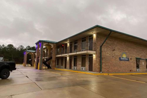 a large brick building with a parking lot at Days Inn by Wyndham Forest in Forest