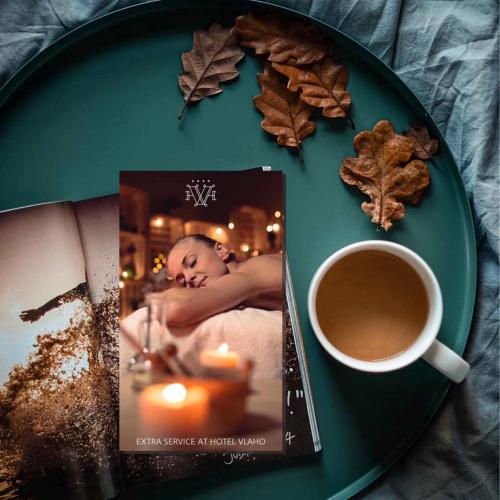 a plate with a book and a cup of coffee at Hotel Vlaho in Skopje