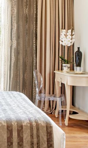 a bedroom with a table and a bed and a desk at Dioni Boutique Hotel in Preveza