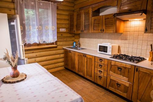a kitchen with wooden cabinets and a white microwave at Karpaty Migovo in Migovo