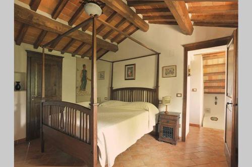 a bedroom with a large bed and a wooden ceiling at Tuscan Charme of Cottage Roccaio Countryside Cortona in Castiglion Fiorentino