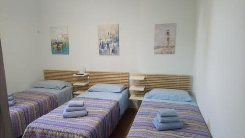 a bedroom with two beds with pillows on them at Casetta Gaia in Latina
