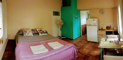 ein kleines Schlafzimmer mit einem Bett und einem Kühlschrank in der Unterkunft apartamento VINTAGE LU in Merlo