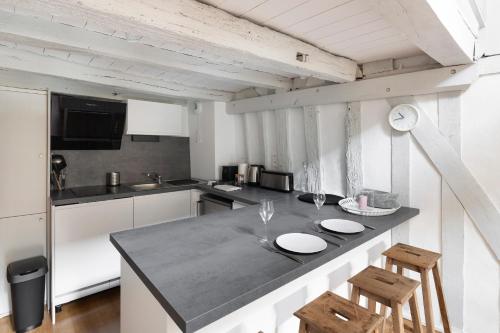 une cuisine avec un comptoir avec deux tabourets dans l'établissement Georgia by Cocoonr, à Rennes