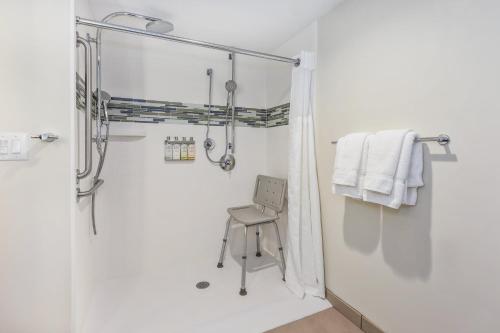 a shower with a chair in a white bathroom at EVEN Hotel Ann Arbor S - University Area by IHG in Ann Arbor