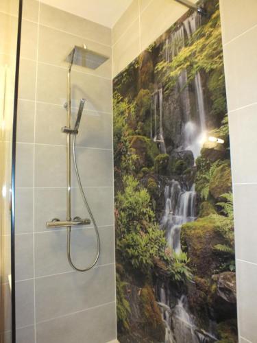 Un baño con un mural de cascada en la pared. en Residence Mifaly, en Châteauroux