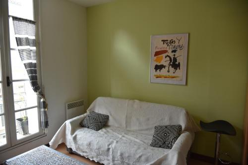 ein Wohnzimmer mit einer weißen Couch in einem Zimmer in der Unterkunft Pied à terre au bord de mer in Sète
