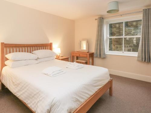 Un dormitorio con una gran cama blanca y una ventana en 1 Southgate en Buxton