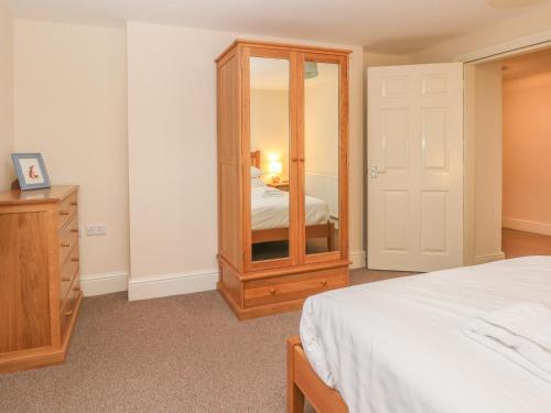 a bedroom with a wooden dresser and a mirror at 1 Southgate in Buxton
