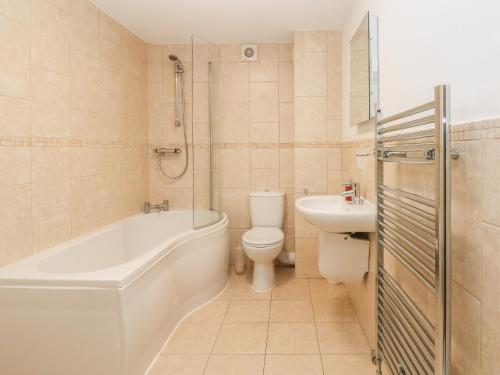 a bathroom with a tub and a toilet and a sink at 1 Southgate in Buxton