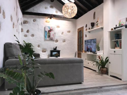 a living room with a couch and a tv at Casa Doña Carmen in Betancuría